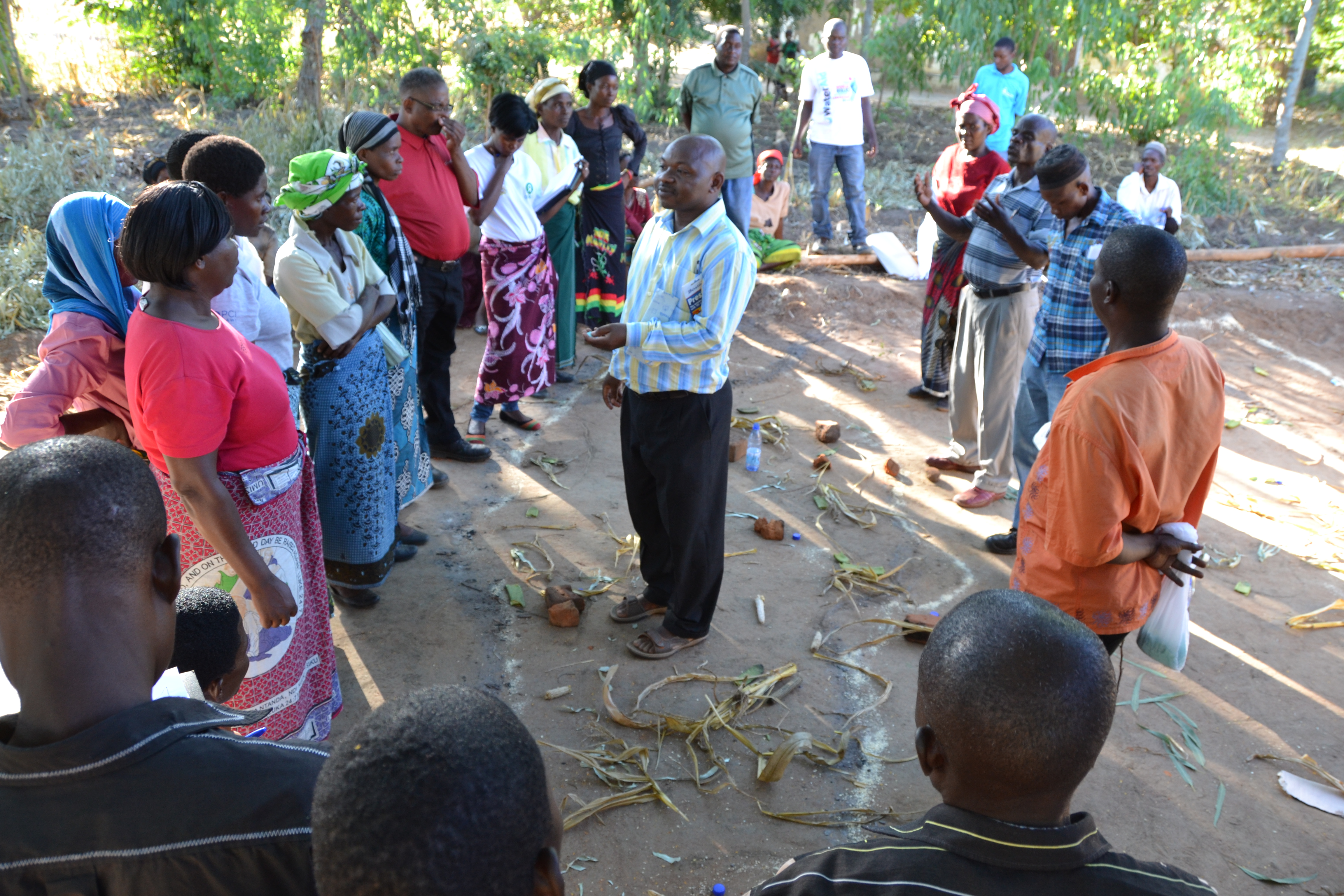 An instructor talks amidst a group of farmers standing in a circle