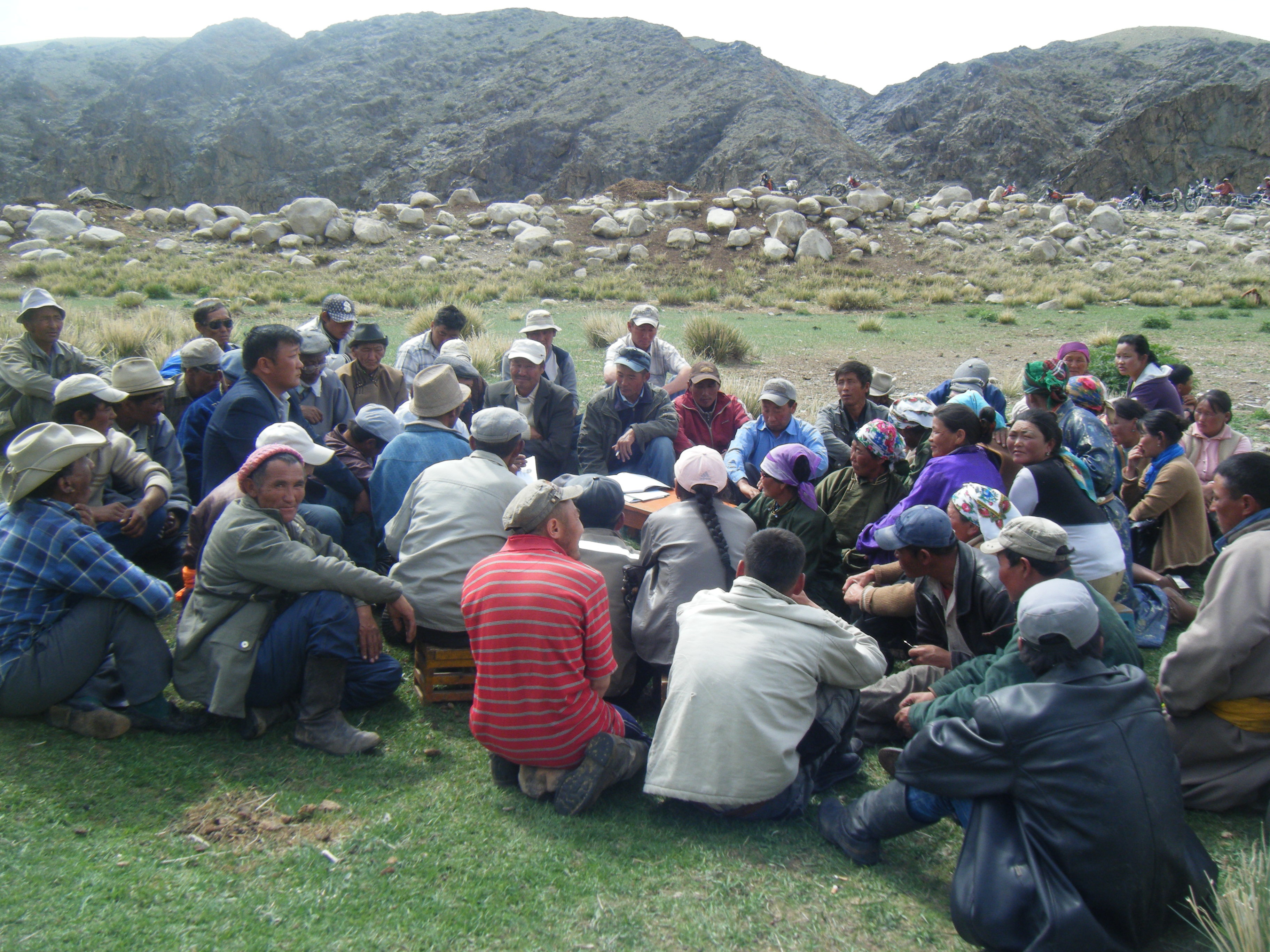 Groupe d’éleveurs et d’éleveuses en pleine discussion, assis sur l’herbe.