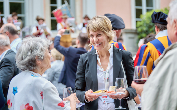 L'immagine mostra l'aperitivo di apertura a Lugano, con al centro la direttrice Ariane Rustichelli.