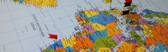 Carte du monde avec petits drapeaux pointant des destinations