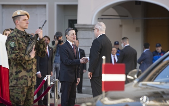 Il presidente della Confederazione Ignazio Cassis stringe la mano al presidente della Lettonia Egils Levits in Piazza Riforma a Lugano. 
