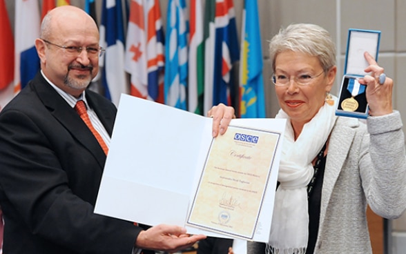OSZE-Generalsekretär Lamberto Zannier überreicht Heidi Tagliavini die Medaille.