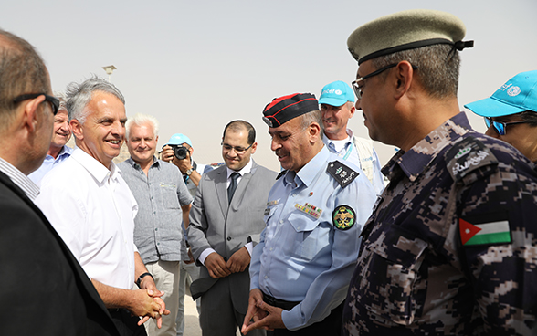 Didier Burkhalter se tient devant une foule alors qu’il arrive dans le camp de réfugiés d’Azraq