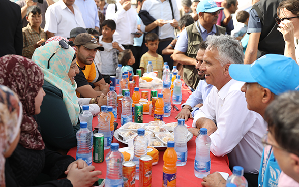 Didier Burkhalter wird von Bewohnerinnen und Bewohnern des Lagers bewirtet.