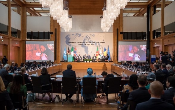 Teilnehmerinnen und Teilnehmer der Tschadsee-Konferenz sitzen in einem Konferenzsaal im Auswärtigen Amt in Berlin.