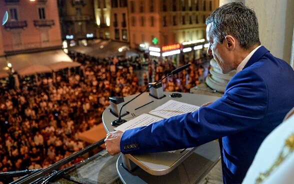 Il Consigliere federale Ignazio Cassis parla alla popolazione a Lugano da un podio.