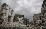 Menschen gehen durch die Trümmer der von Luftangriffen getroffenen syrischen Stadt Idlib.