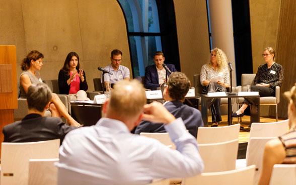 Das Podium und Publikum der Veranstaltung zu «Lebensmittelver-schwendung reduzieren».