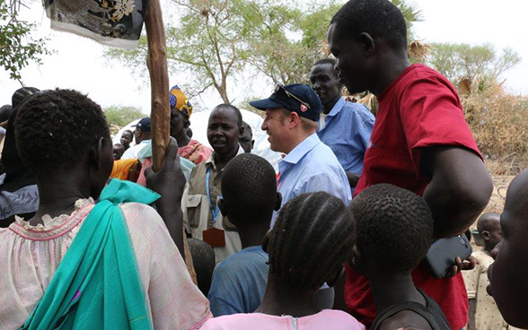 Ein Mitarbeiter der Humanitären Hilfe der Schweiz unterhält sich mit intern Vertriebenen aus der Umgebung von Bor im Südsudan