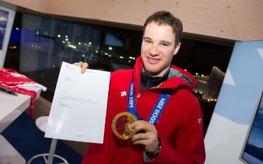 Dario Cologna with the letter of congratulations from Didier Burkhalter, and his gold medal.