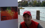 Le conservateur Ashley Woods devant le premier panneau de l’exposition de photos « Making Peace», sur les bords du Rhin à Bâle