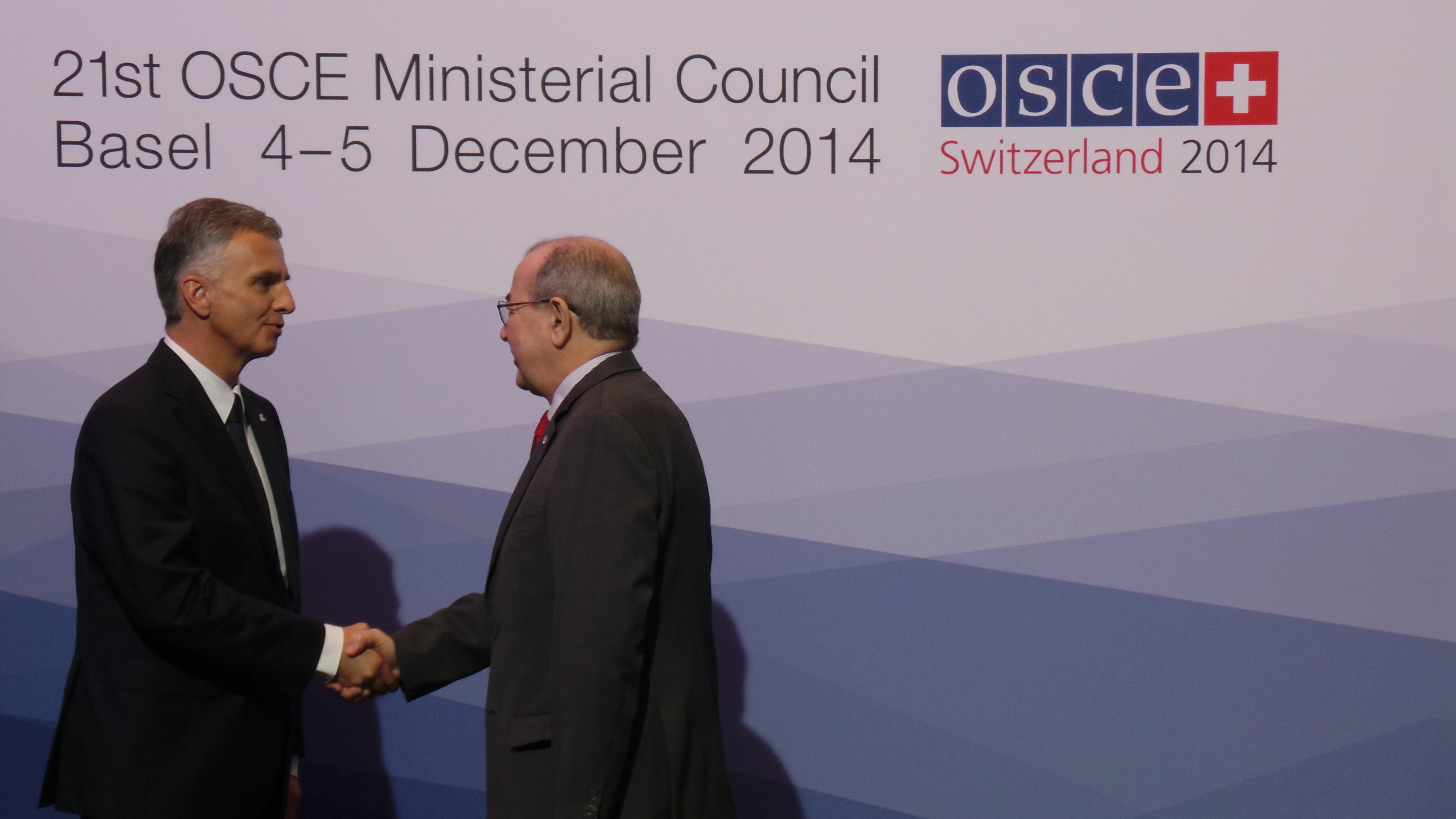 The President of the Swiss Confederation, Didier Burkhalter, greets Mohamed Benhocine, Permanent Representative to the United Nations offices at Vienna at the OSCE Ministerial Council 2014 in Basel