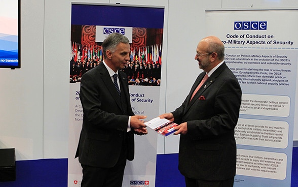 Didier Burkhalter, presidente in carica dell’OSCE per il 2014 e presidente della Confederazione Svizzera, consegna solennemente la pubblicazione commemorativa a Lamberto Zannier, segretario generale dell’OSCE.