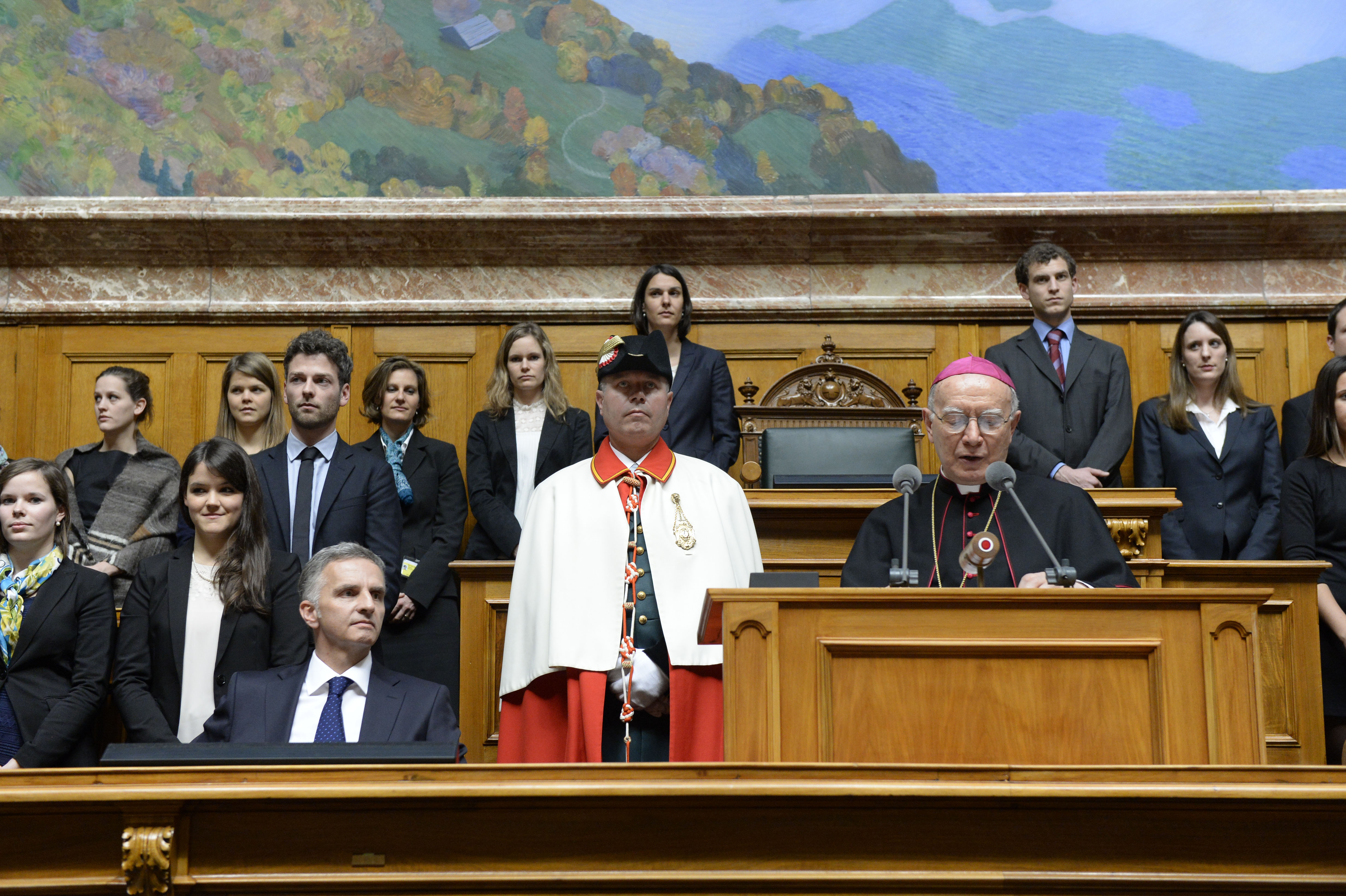 Umgeben von jungen Diplomaten spricht der päpstliche Nuntius zum diplomatischen Corps.