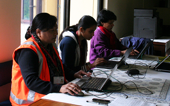 Des employés locaux de l'Ambassade de Suisse au Népal travaillent à une table.