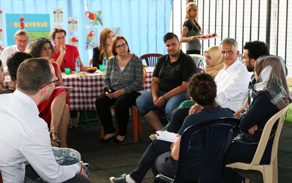 Bundesrat Didier Burkhalter diskutiert mit jungen Männern und  Frauen in Hay Al-Gharbeh, einem benachteiligten Viertel im Süden der libanesischen Hauptstadt, über die schwierigen Lebensumstände und Zukunftsperspektiven. © EDA