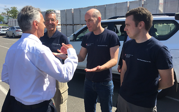 Didier Burkhalter im Gespräch mit drei Mitarbeitern der schweizerischen Humanitären Hilfe in Mariupol.