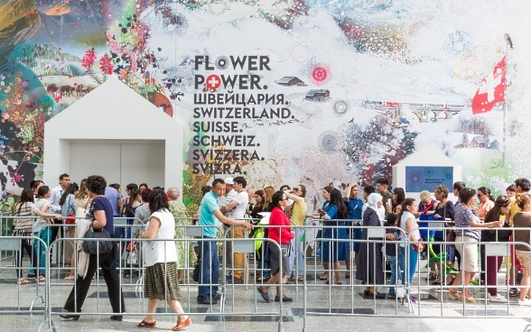 Des visiteurs attendent devan le Pavillon Suisse à Astana. 