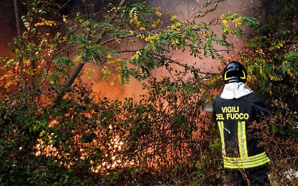 Un pompiere italiano lotta contro l’incendio.