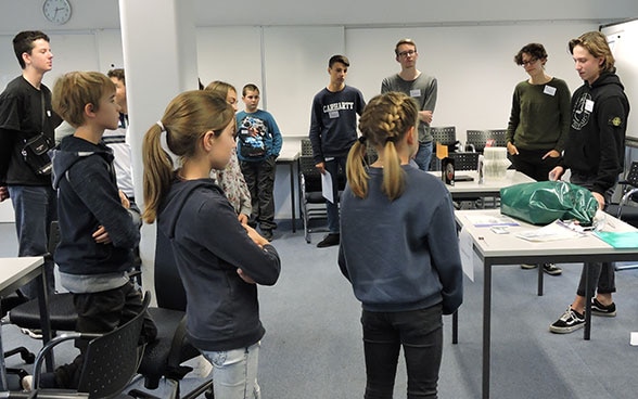 Groupe de jeunes écoutant les explications d’un collaborateur du DFAE.
