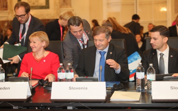 Le conseiller fédéral Ignazio Cassis s’approche des tables des ministres des affaires étrangères suédois et slovène, Margot Wallström et Karl Erjavec.