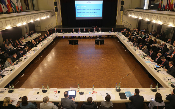 Delegates at the second plenary meeting of the IHRA in a hall.