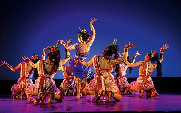 Seven colourful dancers on one stage.
