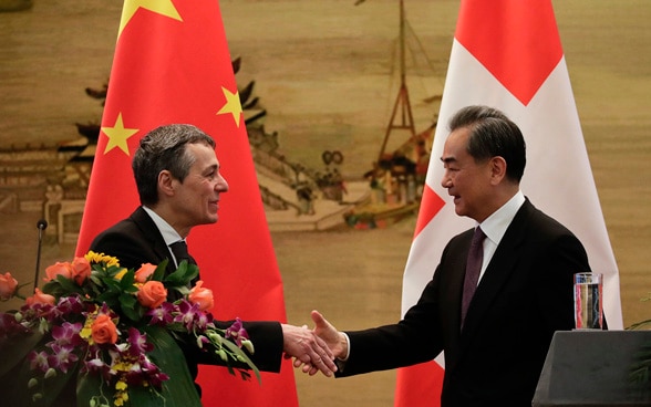 Le ministre suisse des affaires étrangères Ignazio Cassis serre la main du conseiller d'Etat et ministre des affaires étrangères chinois, Wang Yi, après leur conférence de presse commune à Pékin, le 3 avril 2018. 