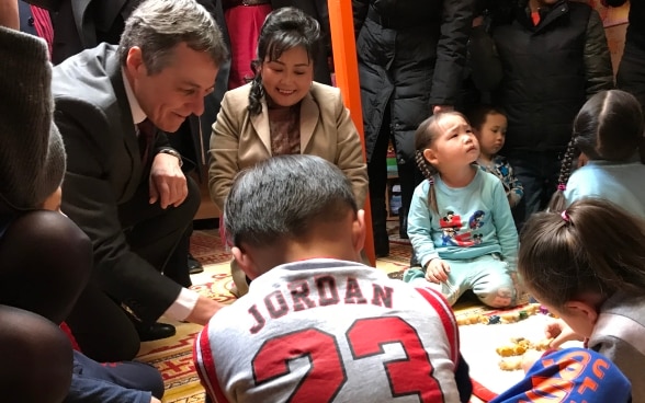 Federal Councillor Cassis plays in a school with Mongolian children.