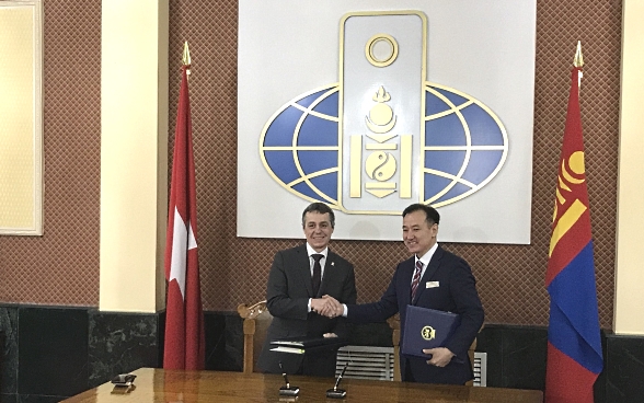 Bundesrat Ignazio Cassis und sein mongolischer Amtskollege Damdin Tsogtbaatar schütteln sich bei einem offiziellen Treffen die Hände.