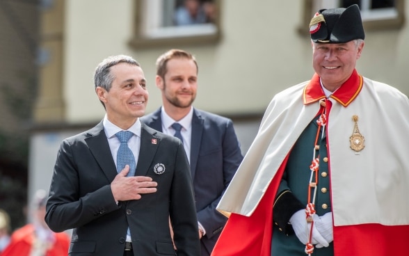 Federal Councillor Ignazio Cassis smiles at the Appenzell people with his hand on his chest.