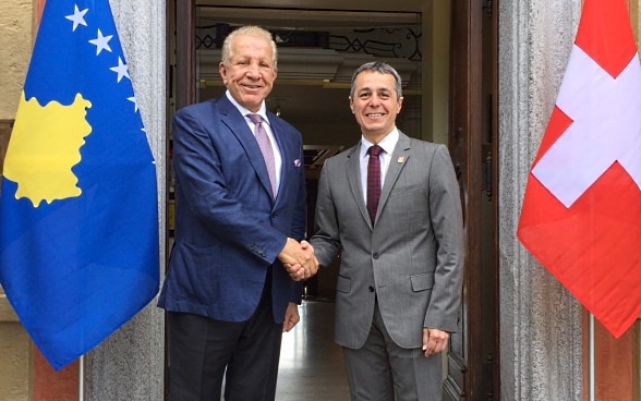 Il consigliere federale Ignazio Cassis e il ministro degli esteri kosovaro Behgjet Pacolli siedono a un tavolino e parlano.