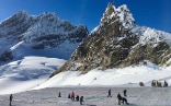 Auf dem Aletschgletscher setzen Personen die Postkarte zusammen. Im Hintergrund ist das Jungfraujoch zu sehen.