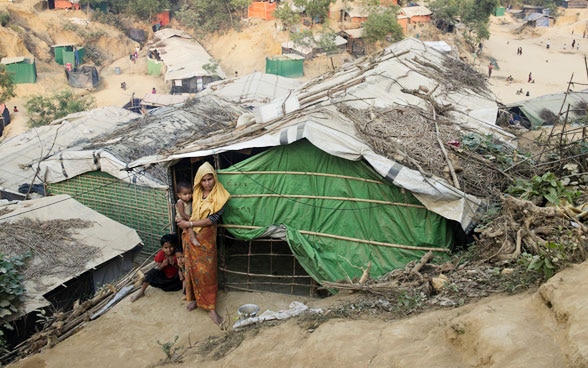 Una donna e il suo bambino si trovano di fronte a una capanna improvvisata nel campo profughi di Cox’s Bazar in Bangladesh.