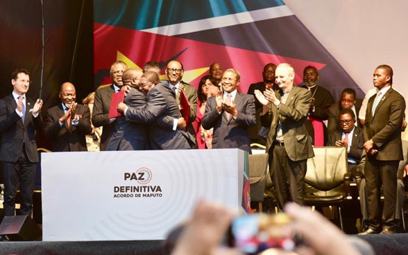 Les représentants des parties au conflit s'embrassent après la signature de l'accord de paix.
