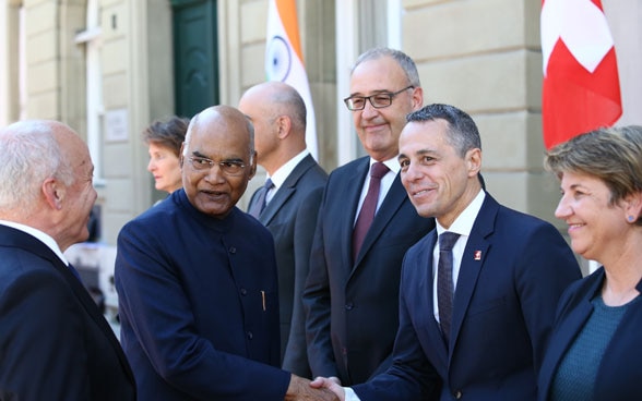 Le président indien et Ignazio Cassis se serrent la main en présence du l’ensemble du conseil fédéral.