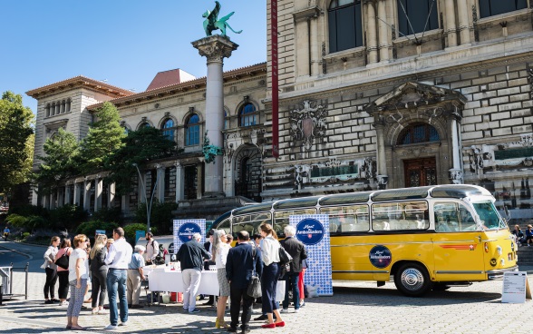 Panoramica dell’autobus, dei diplomatici, del pubblico e de La Riponne a Lausanne