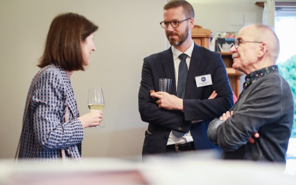 Une ambassadrice suisse et un ambassadeur suisse discutent avec un membre du public.