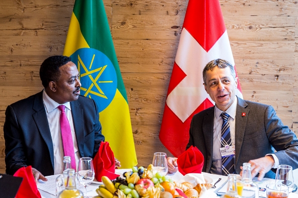 Federal Councillor Cassis is sitting at a richly covered table in conversation with Ethiopian Foreign Minister Gebeyehu. The flags of Switzerland and Ethiopia can be seen in the background.