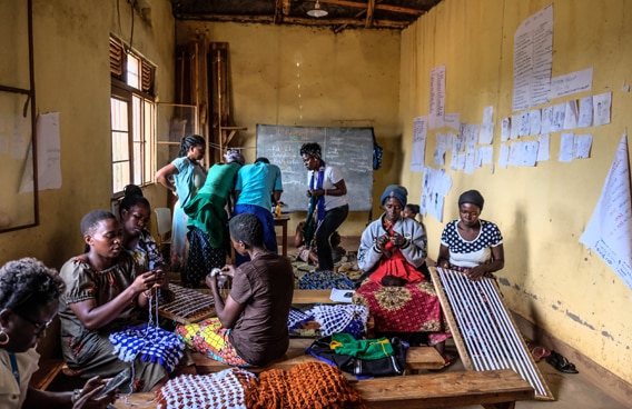 Frauen in einem Raum weben im Rahmen eines Programms zur Verringerung der Gewalt gegen Frauen und zur Verbesserung ihrer Stellung in Burundi, in Ruanda und in der Demokratischen Republik Kongo.