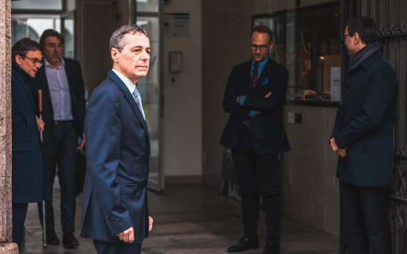 Le conseiller fédéral Cassis se tient à l'entrée du bâtiment du gouvernement.