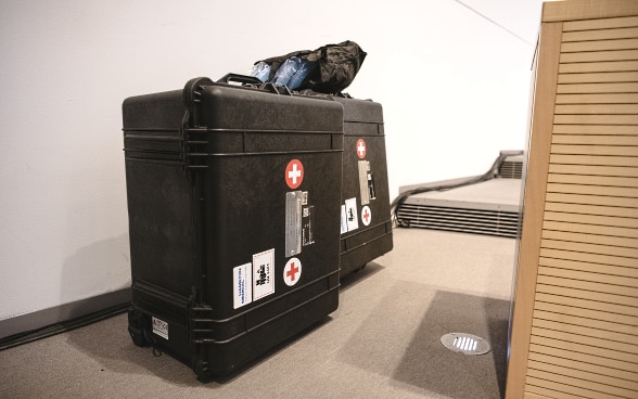 Zwei Koffer stehen am Rand des Parlamentssaals. In den Koffern sind zwei Beatmungsgeräte verpackt.