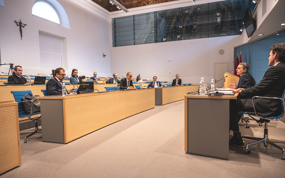 Dans la salle du Parlement de Bellinzone, le conseiller fédéral Cassis s'entretiendra avec les délégations des gouvernements des cantons des Grisons et du Tessin. Le secrétaire d'État Balzaretti est assis à la droite du conseiller fédéral Cassis.