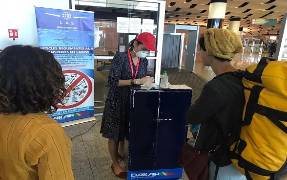 Two Swiss women carry out administrative formalities at Dakar airport before boarding a return flight to Switzerland. 
