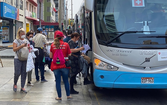  Plusieurs touristes montent dans un bus à destination de Lima. Le transport est organisé par l'ambassade de Suisse.