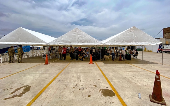 Tents are located at the airfield of the airport of Lima. Below them are the passengers of the return flight to Zurich.