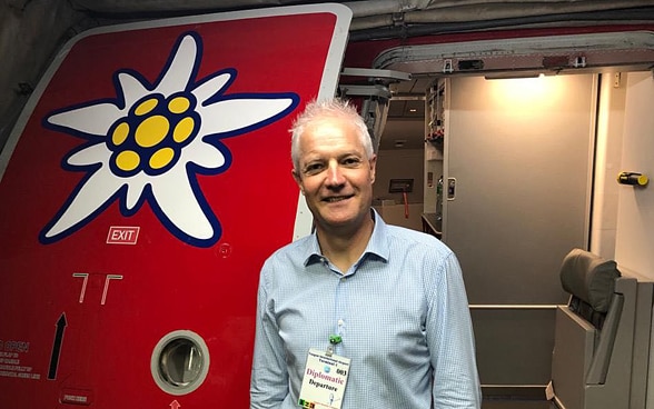 Der Schweizer Botschafter in Myanmar, Tim Enderlin, steht an der Tür des Edelweiss-Flugzeugs in Yangon. Ein Edelweiss ist auf die Tür gemalt. 