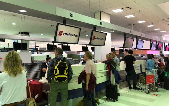 Passengers are at the check-in counter to check in for the Sydney-Zurich flight. 