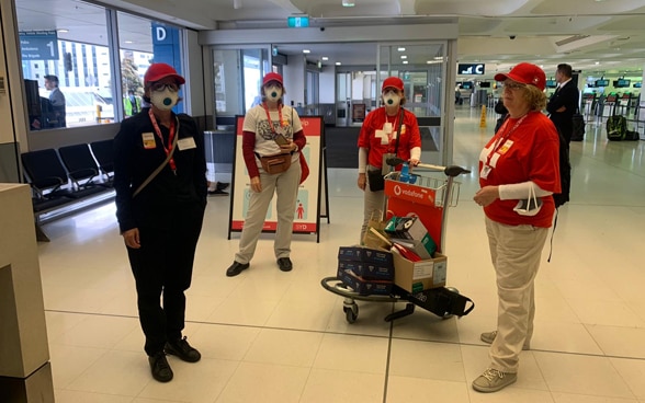 Die Mitarbeitenden des Schweizerischen Generalkonsulats in Sydney tragen Schutzmasken, während sie sich auf dem Flughafen Kingsford-Smith in Sydney aufhalten. 