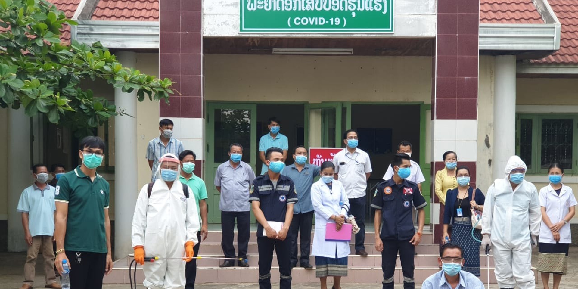 Le personnel d’un hôpital du Laos équipé de masques de protection devant l’entrée de l’unité dédiée au COVID-19. 